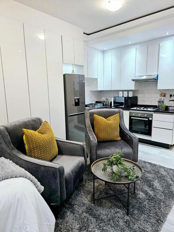 a living room with two chairs and a coffee table at Millenium Heights Borrowdale in Harare