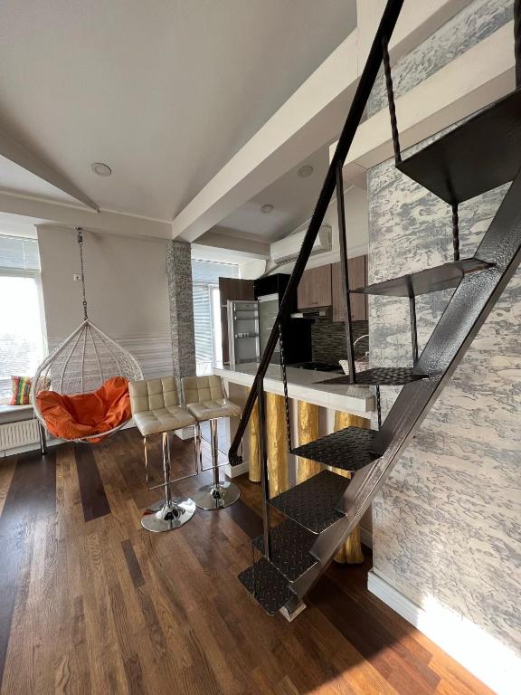 a living room with a spiral staircase in a house at Columna Central Park Apt in Chişinău