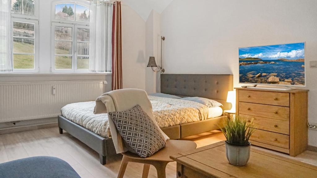 a bedroom with a bed and a chair and a table at Apartment am Nationalpark Sächsische Schweiz in Sebnitz