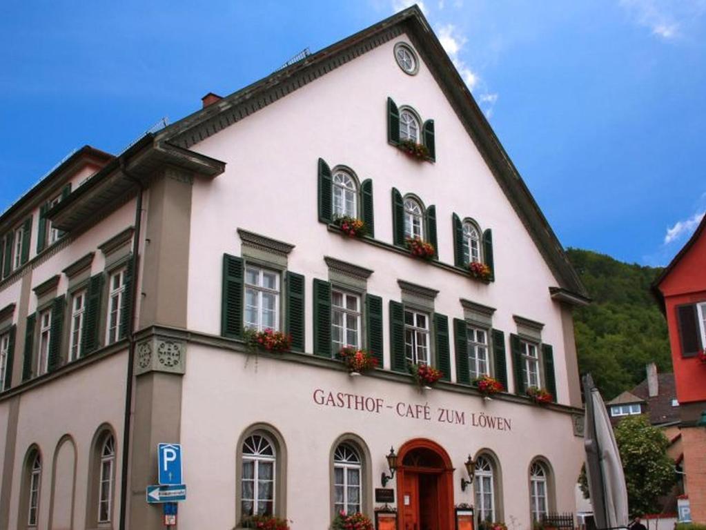 a large white building with green shuttered windows at Hotel Löwen in Blaubeuren