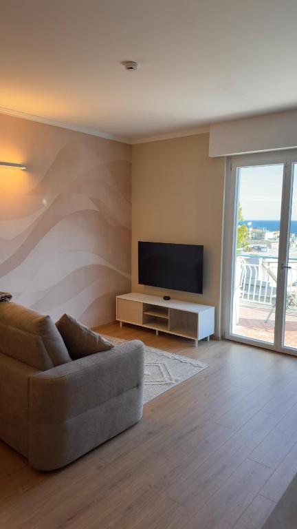 a living room with a couch and a flat screen tv at NB Luxury Attico Vista Mare in Sanremo