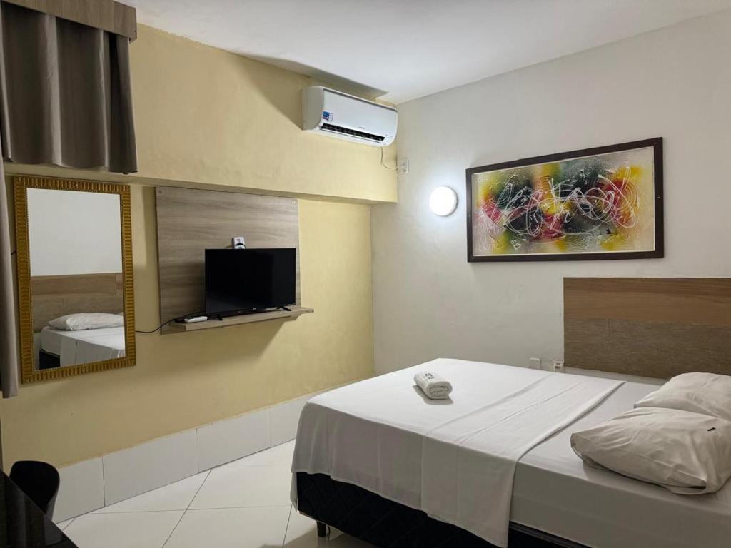 a bedroom with a bed and a tv on the wall at Hotel orla House in Petrolina