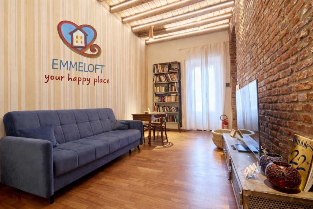 a living room with a couch and a brick wall at Emme Loft I First Moon - Exclusive Design Apartment with balcony in Milan