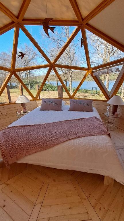 a large bed in a room with a large window at Dôme géodésique Le petit prince in Le Rousset