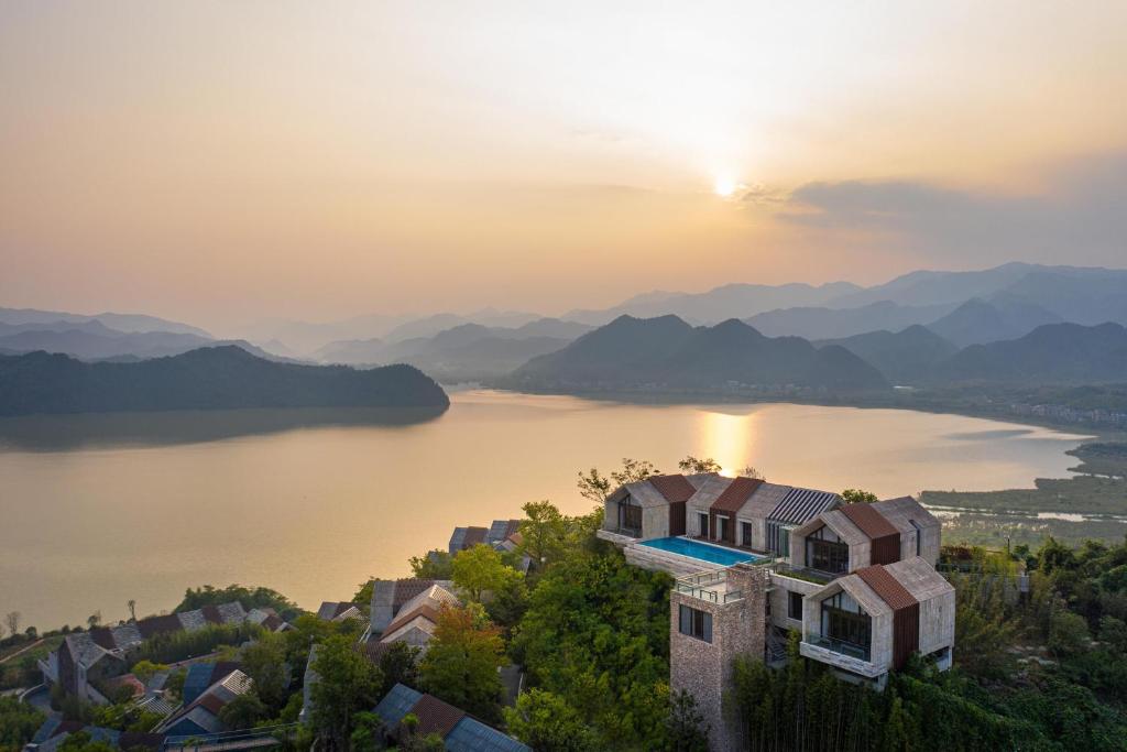 a house on a hill with a view of a lake at Conrad Hangzhou Tonglu in Yinzhu