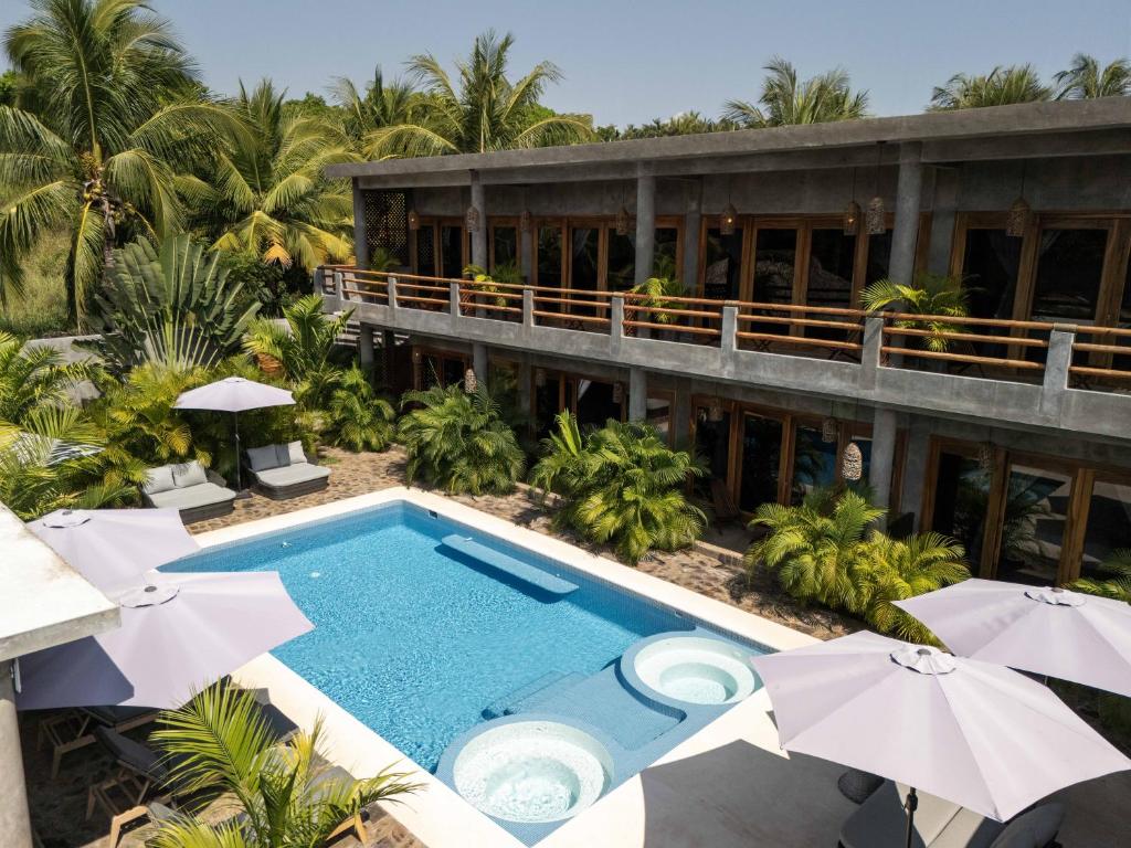 an aerial view of a resort with a swimming pool and umbrellas at Hotel Boutique Pikiliki - ADULTS ONLY in Brisas de Zicatela