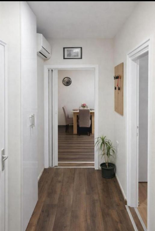 a hallway with white walls and a table at Apartman Centar 1 in Šabac