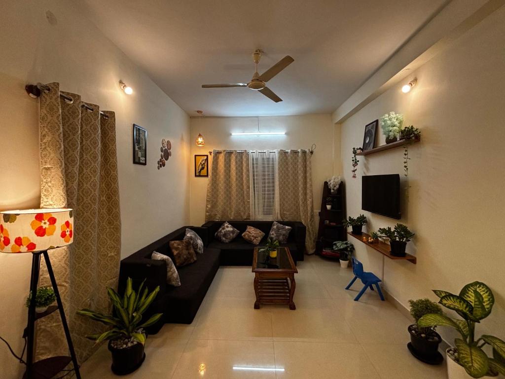 a living room with a couch and a tv at Hazel's ELiTE Homestay 2bhk in Mysore