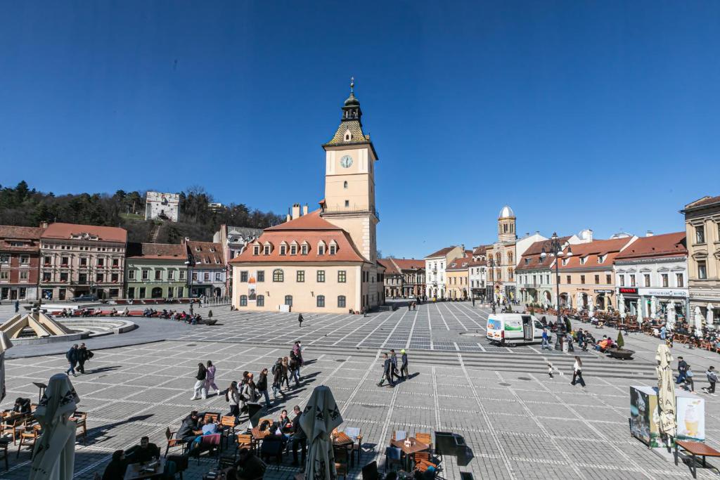 a large square with a clock tower in a city at Residence Piata Sfatului in Braşov