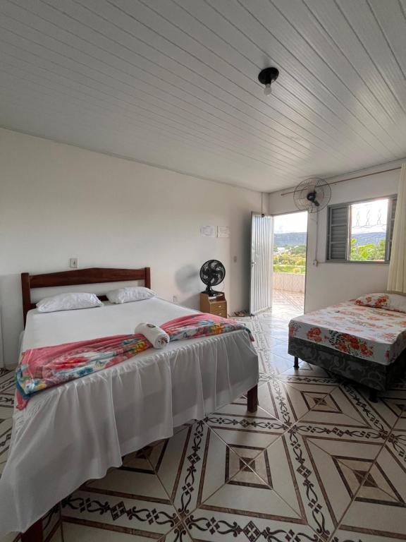 a bedroom with a large bed and a window at Suítes FM in Cavalcante
