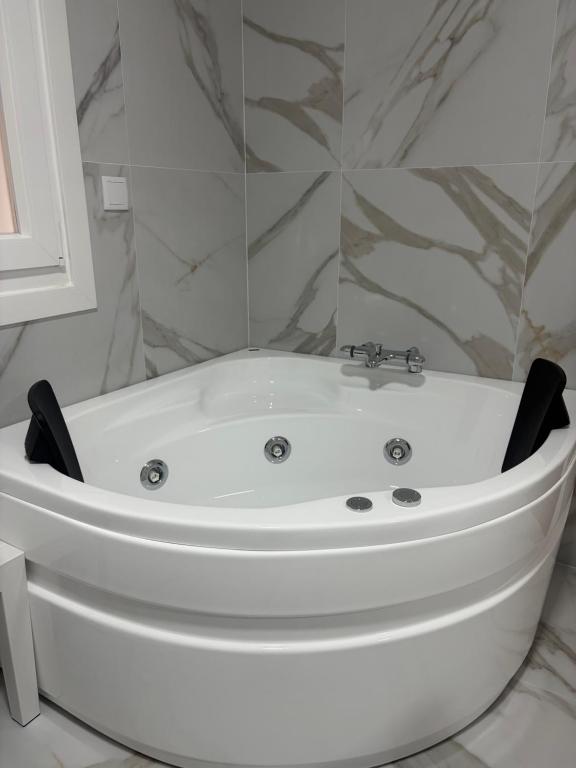 a white bath tub sitting in a bathroom at Casa da Fonte in Rianjo