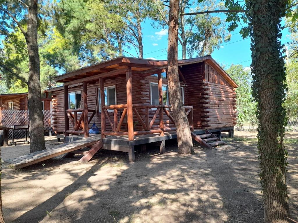 a log cabin in the woods with trees at La Ardilla Chueca in Luján