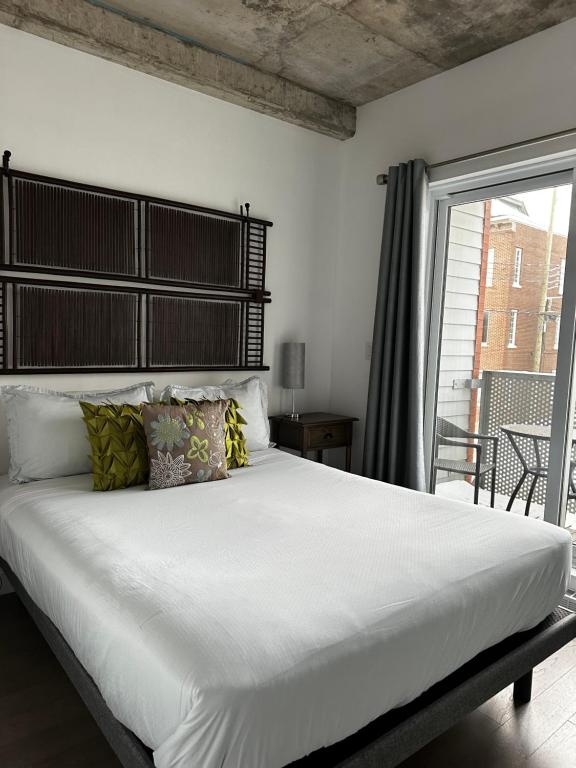 a bedroom with a large white bed and a balcony at Condo "Imagine" - stationnement privé inclus in Quebec City