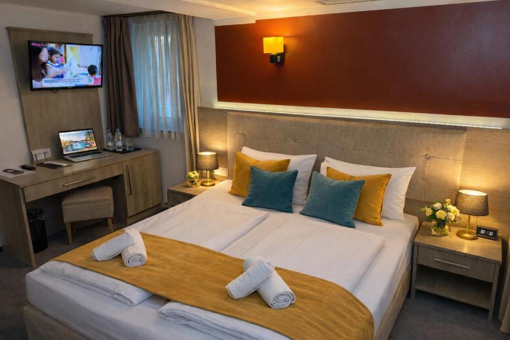 a hotel room with a large bed and a desk at Alpha & Omega Hotel Stuttgart - air-conditioned in Stuttgart
