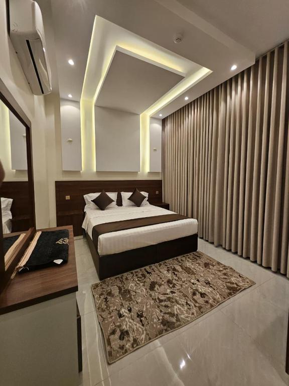 a bedroom with a bed and a table and a bed sidx sidx sidx at أجنحة توليب للشقق المخدومة in Hafr Al-Batin