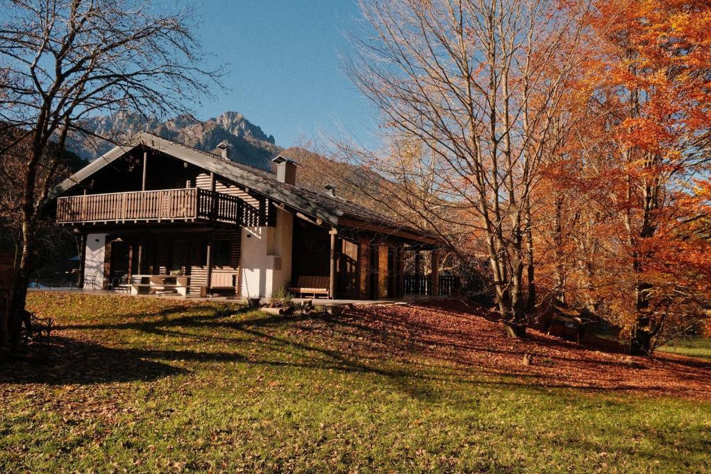 a house with a porch and a balcony on a yard at Rèfol Lodge Val di Ledro in Pur