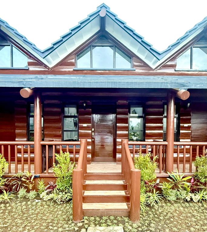 a log cabin with a staircase leading to the front door at Log Cabin Tagaytay in Tagaytay