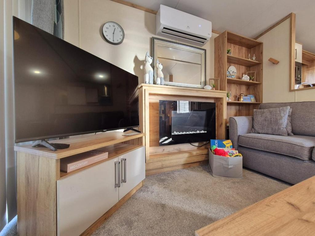 a living room with a large flat screen tv at Whitstable Hemsworth Villa in Seasalter