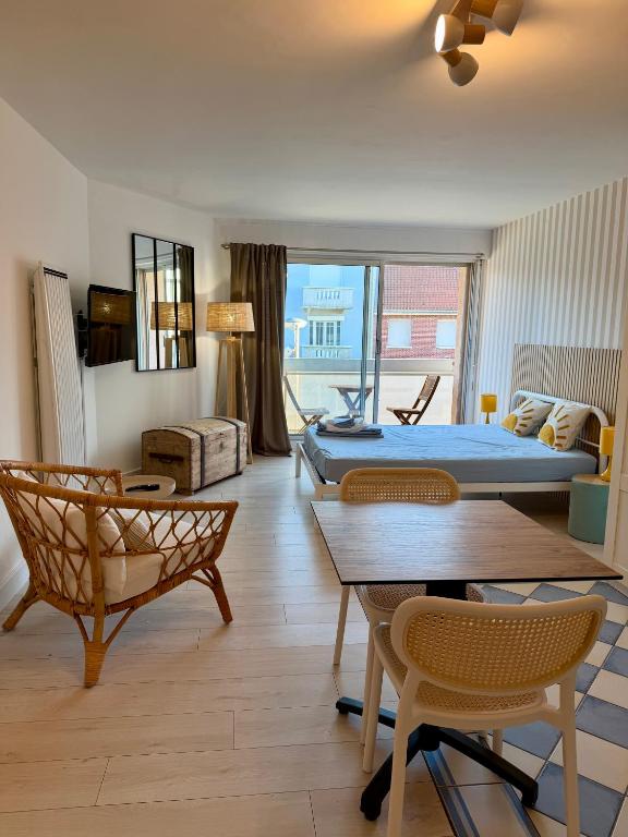 a living room with a bed and a table and chairs at Studio Ti’Sable 50m de la plage in Fort-Mahon-Plage