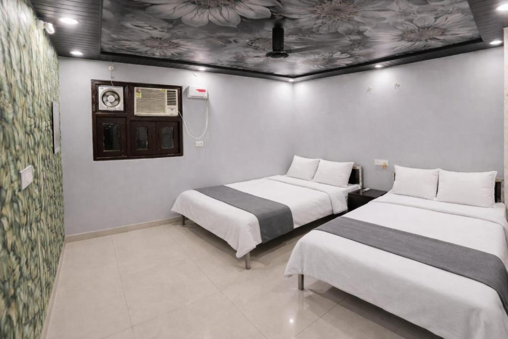 a room with two beds and a clock on the ceiling at Hotel In Kashi in Varanasi