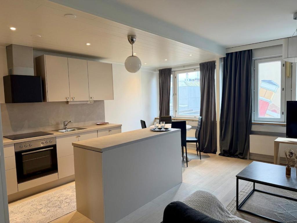 a living room with a kitchen and a living room with a table at Apartment Kopin5 in Kokkola