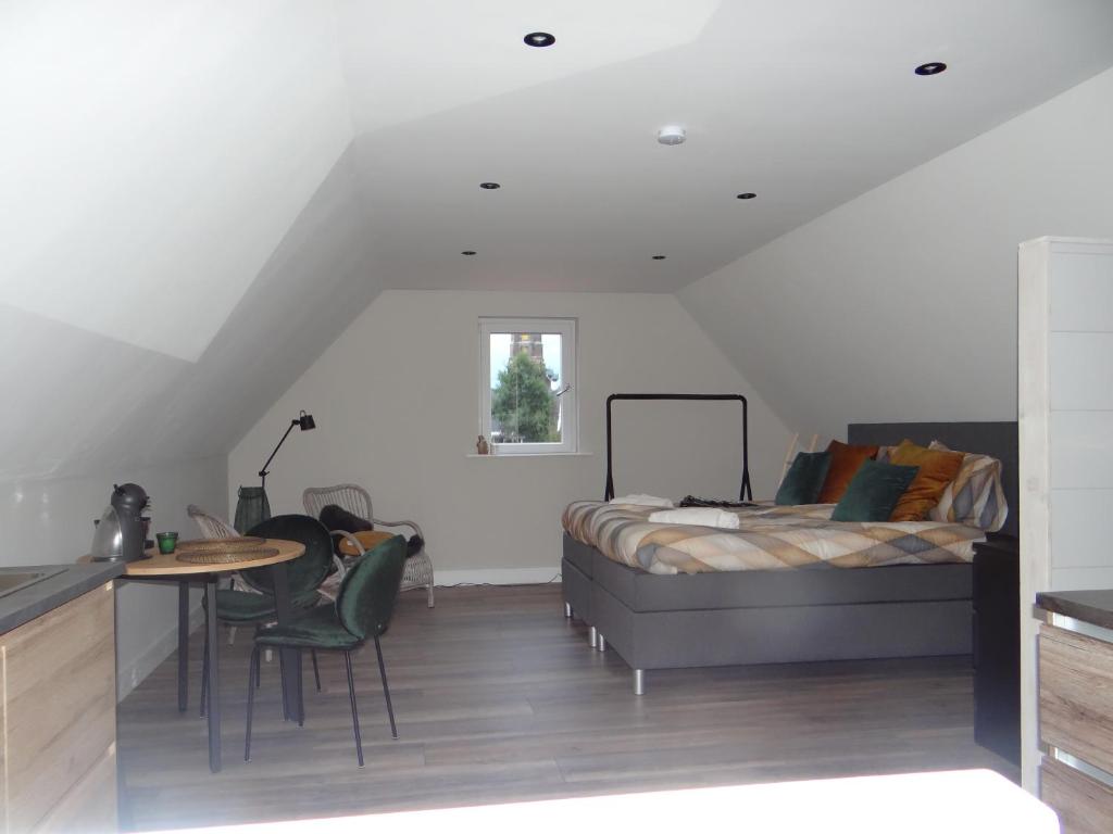 a bedroom with a bed and a table and chairs at Torenzicht in Kapelle