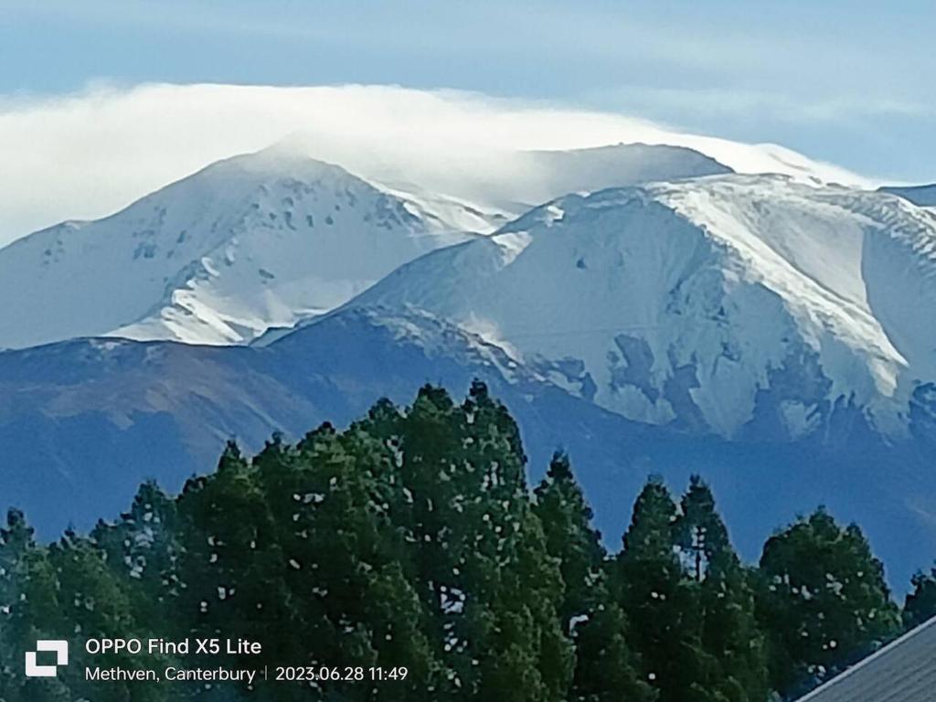 a snow covered mountain with trees in front of it at Mt Hutt Views at 23 Methven in Methven