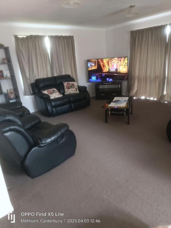 a living room with couches and a flat screen tv at Methven Crash Pad in Methven