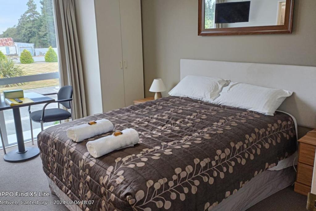 a bedroom with a bed with two towels on it at Mt Hutt Studio at 23 Methven in Methven