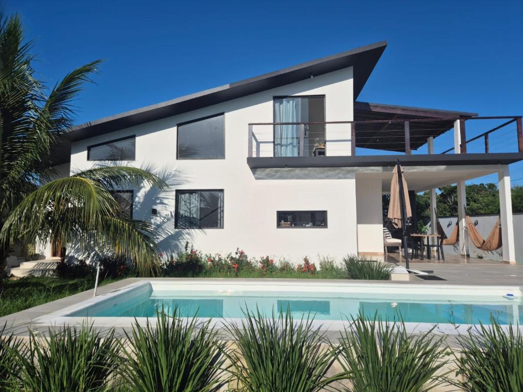 a house with a swimming pool in front of it at Casa Telhado Inclinado in Saquarema