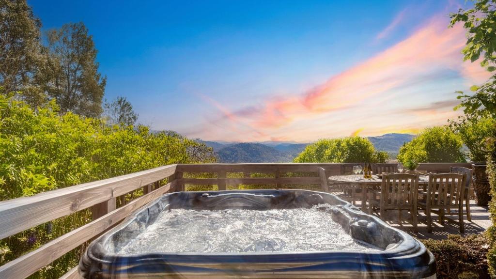 a jacuzzi tub on a deck with a table at Asher by AvantStay in Asheville