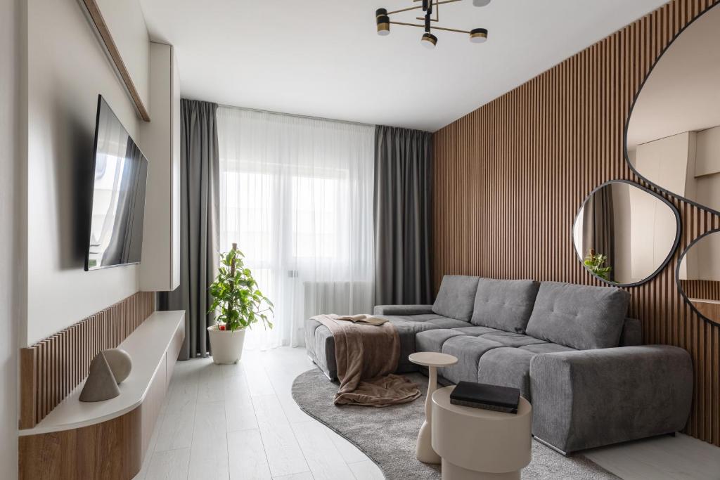 a living room with a couch and a mirror at The Signature by D'or Selection in Bucharest
