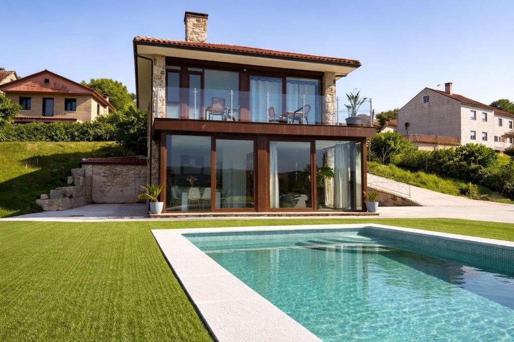 a house with a swimming pool in front of a house at CESANTES VILLAGE e in Pontevedra