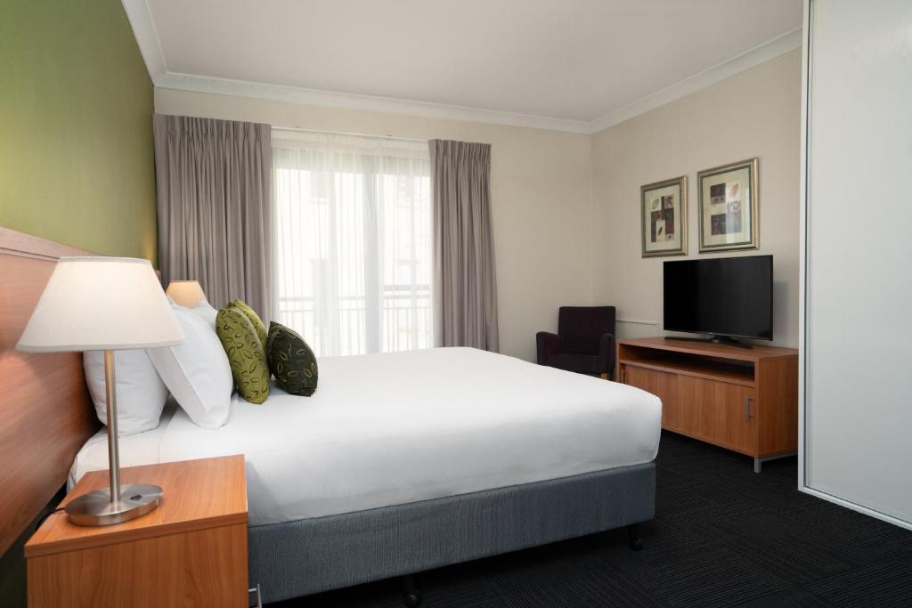 a hotel room with a bed and a television at Leisure Inn Spires in Leura