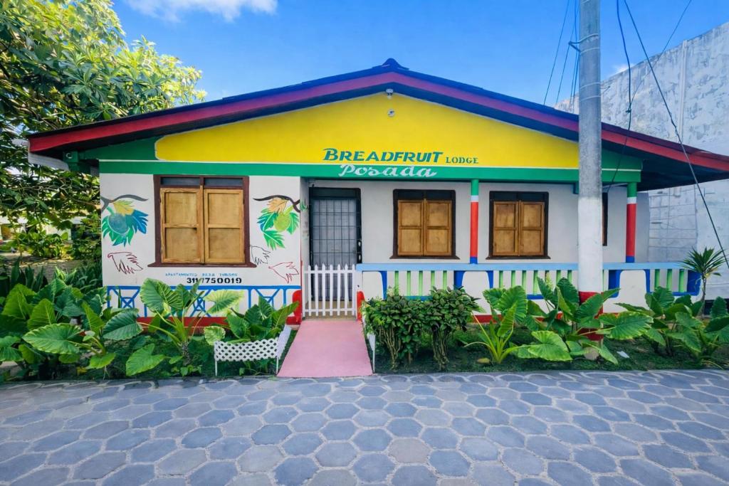 ein kleines weißes Gebäude mit zweifarbigen in der Unterkunft Bread Fruit Lodge in San Andrés