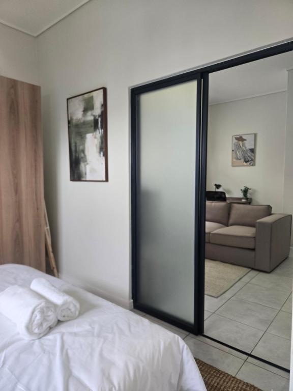 a bedroom with a bed and a living room with a couch at Sir Chase Place in Boksburg