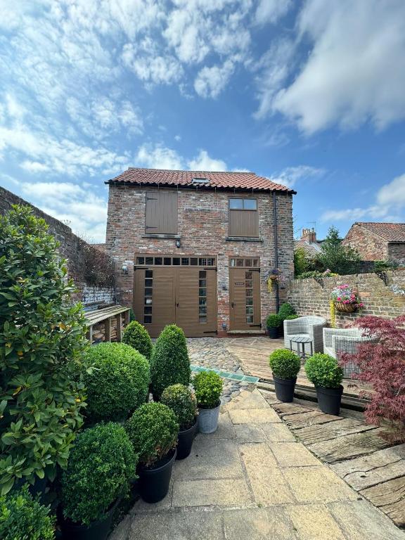 a brick house with a patio and some bushes at The Old Hayloft Beverley Town Centre in Beverley