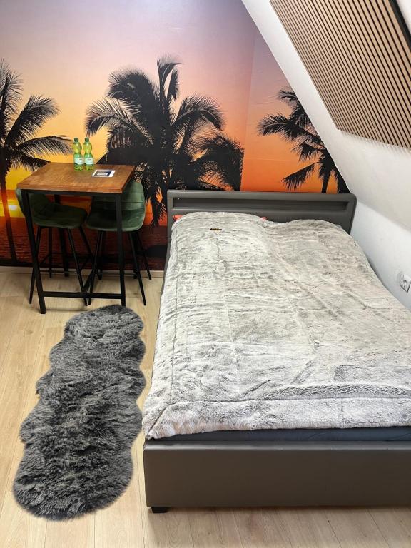 a bedroom with a bed and a table and palm trees at ANCiENT CiTY WALL in Nuremberg