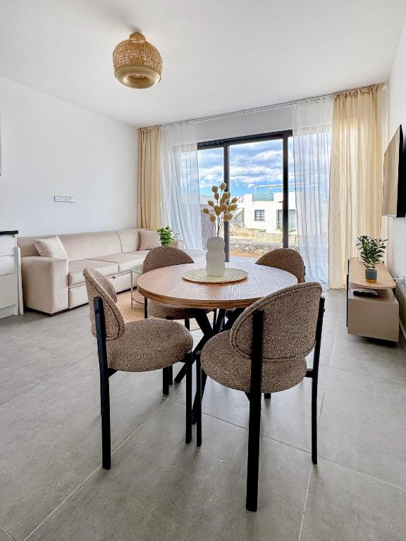 a living room with a table and chairs and a couch at Kantara Beach Resort Apartment FeMa in Athalassa