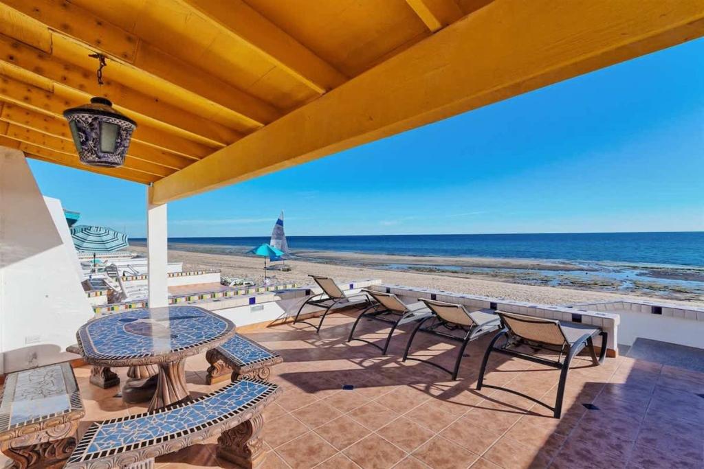 a patio with chairs and a table and the beach at Beautiful Beachfront Condo Olas I 16 in Puerto Peñasco
