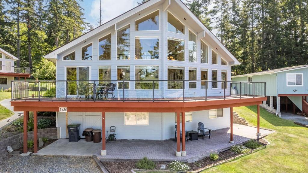 a large white house with a large deck at Harborview Getaway by AvantStay in Langley