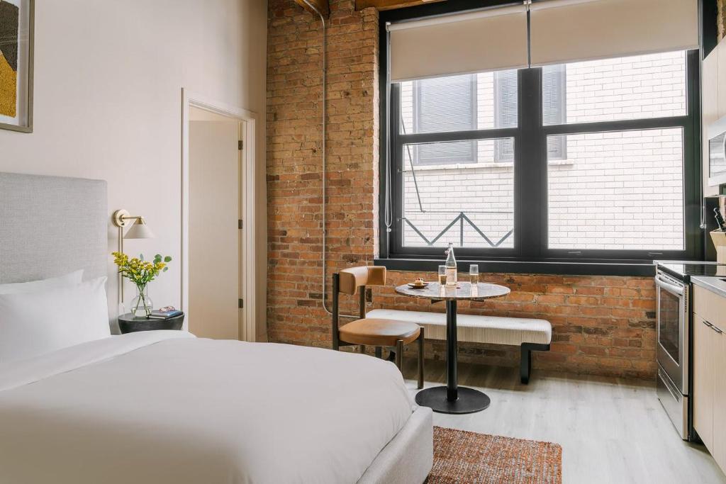 a bedroom with a bed and a table and a window at LIVN West Loop Chicago Classic Queen Studio in Chicago