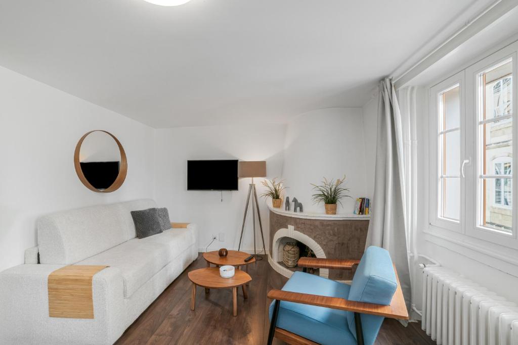 Ein weißes Wohnzimmer mit weißem Sofa und Kamin in der Unterkunft Boel 4 Studio in Genf