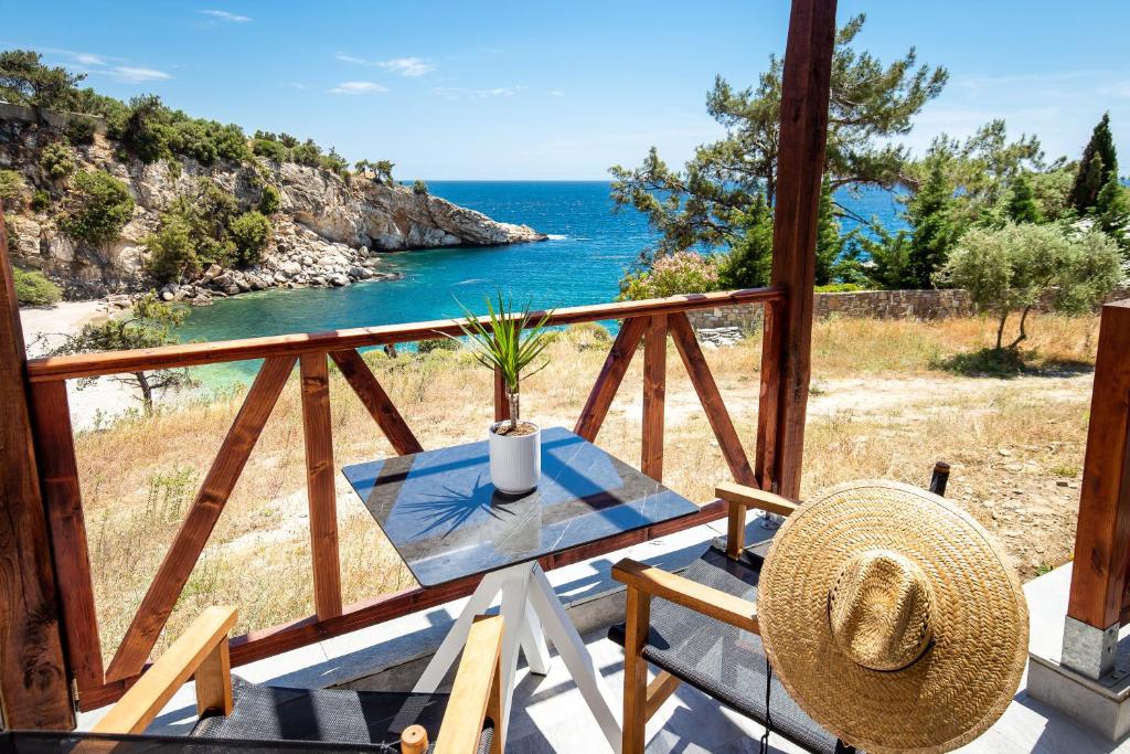 a table and chairs on a balcony with the ocean at East Coast in Alyki