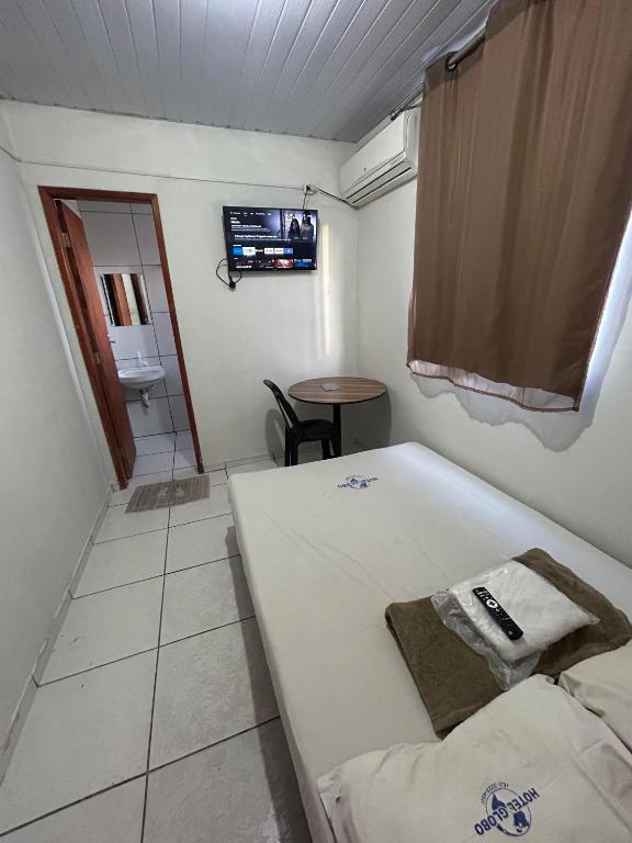 a small room with a bed and a bathroom at Hotel Globo in Goiânia