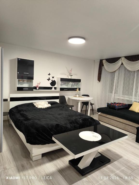 a bedroom with a large bed and a living room at Atpūta pie Gora in Rēzekne