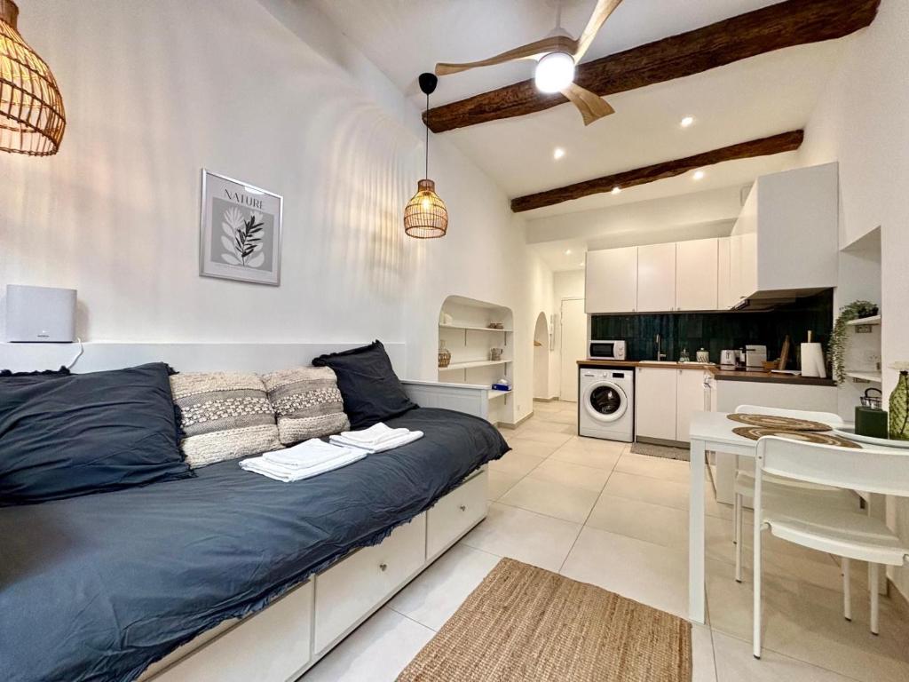 a bedroom with a large bed and a kitchen at Casa Sauge in Grasse