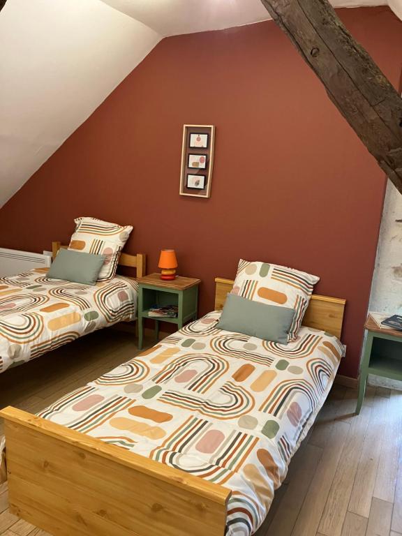 two beds in a room with red walls at Locéane in Le Pêchereau