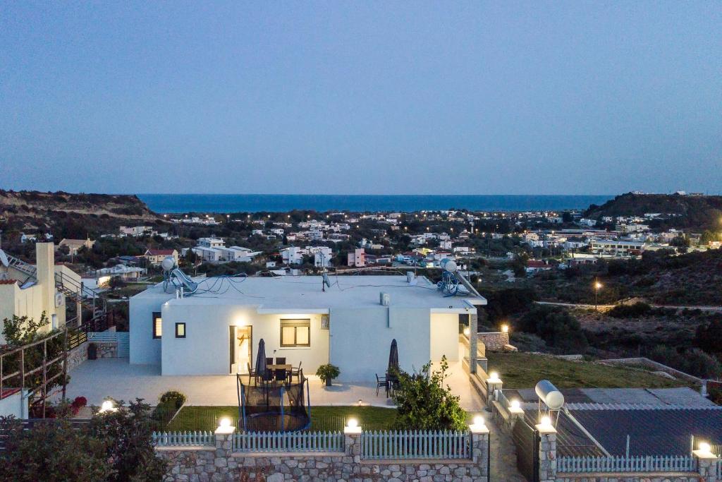 a white house with a view of a city at night at Sebastian Villas in Afantou