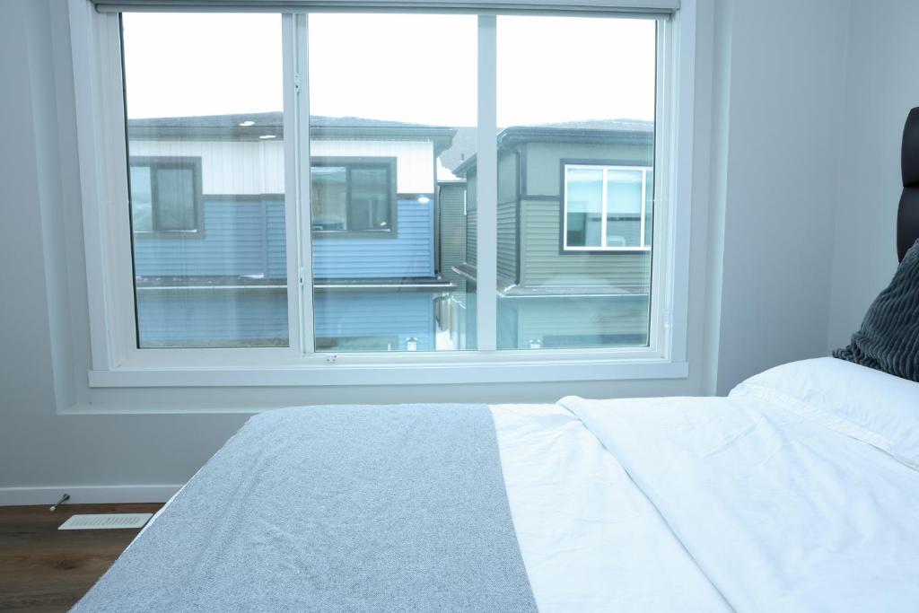 a bedroom with a large window and a white bed at Kris Comfort Garden Suite in Edmonton